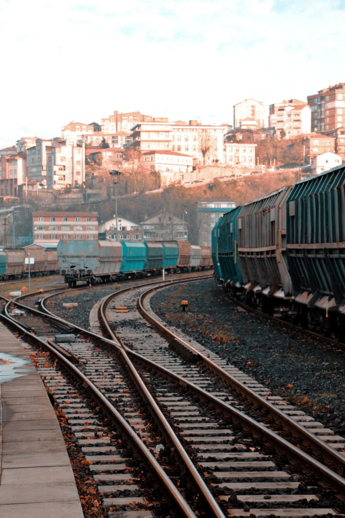 The Art of Drawing Readers In: Your attractive post title goes here Freight trains on winding tracks near a hillside town on a clear day.