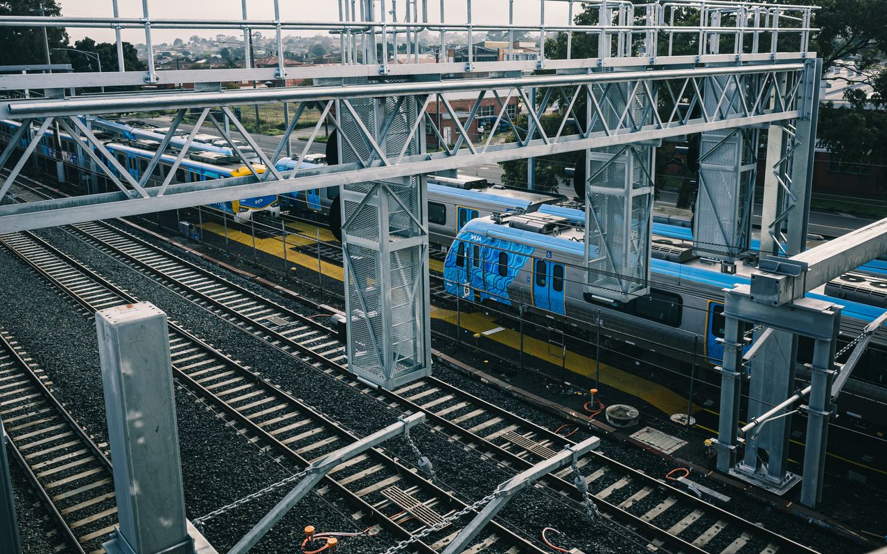 Services Aerial view of modern railways and blue train in urban setting, showcasing transportation infrastructure.